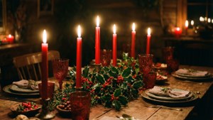 Et bord med levende lys og kristtorn, som skaper en varm og intim juleatmosfære. — God jul Bakgrunner