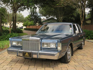 Majestetisk 1986 Lincoln Town Car parkert på asfaltert oppkjørsel — Kule biler GIF Bakgrunner