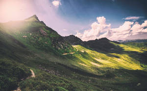 Grønt fjell med rent landskap og hvite skyer, panorama-effekt.