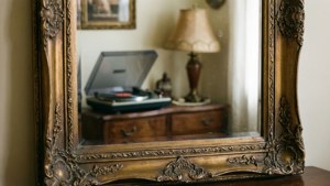 Et utsmykket vintage-speil som reflekterer en koselig retrointeriør.