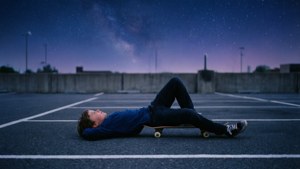 En skatergutt som slapper av under en stjernehimmel på en stille plass. — Skater boy estetikk Bakgrunner