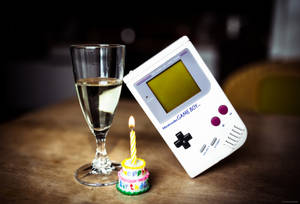 Game Boy-replika med glass og kake bakgrunnsbilde