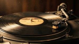 Et varmt, nostalgisk nærbilde av en vinylplate på en platespiller. — Musikkestetikk Bakgrunner